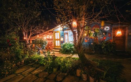 a house lit up at night with lights at Orchards House - The Hidden Tribe in Manāli