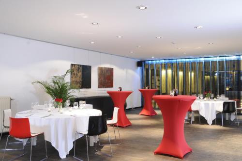 une salle à manger avec des tables et des chaises rouges dans l'établissement Corbie Mol, à Mol