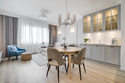a kitchen and dining room with a table and chairs at Apartamenty Tespis - Francuska Atal Park in Katowice