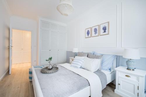 a white bedroom with a bed and a couch at Apartamenty Tespis - Francuska Atal Park in Katowice