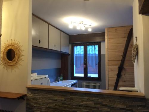 uma pequena cozinha com um lavatório e uma janela em Les Esserts em Les Houches