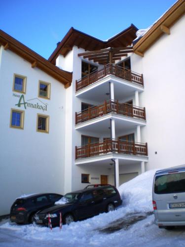 a building with two cars parked in the snow at Haus König in Obergurgl