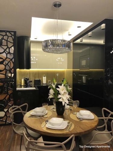 mesa de comedor con sillas y lámpara de araña en Top Designed Apartments en Gdansk