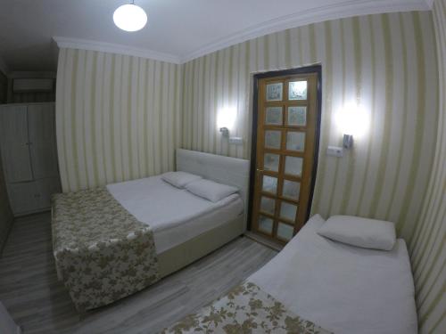 a hotel room with two beds and a window at Pınar Vintage House in Pamukkale