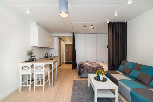 ein Wohnzimmer und eine Küche mit einem Sofa und einem Tisch in der Unterkunft Vilnius City Centre apartment in Vilnius