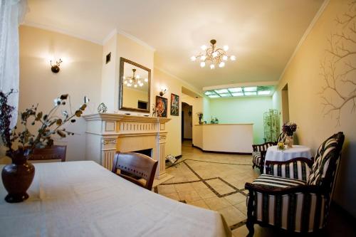 a living room with a fireplace and a table and chairs at Villa Oselya in Kyiv