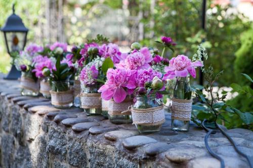 a row of vases filled with flowers on a stone wall at Villa Oselya in Kyiv