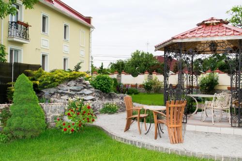 a garden with a gazebo and a table and chairs at Villa Oselya in Kyiv