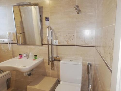 a bathroom with a toilet and a sink and a shower at Hotel Roca Bella in Es Pujols