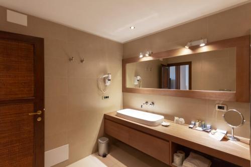 bagno con lavandino e specchio di Hotel Simius Playa a Villasimius