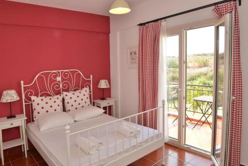 a bedroom with a white bed and a balcony at Country Villas in Stelida