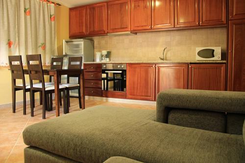 - une cuisine avec des placards en bois, une table et des chaises dans l'établissement Casa da Mineira T1, à Gerês
