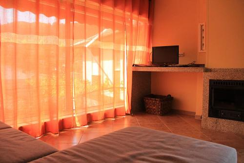 a bedroom with a bed and a window with curtains at Casa da Mineira T2 in Geres