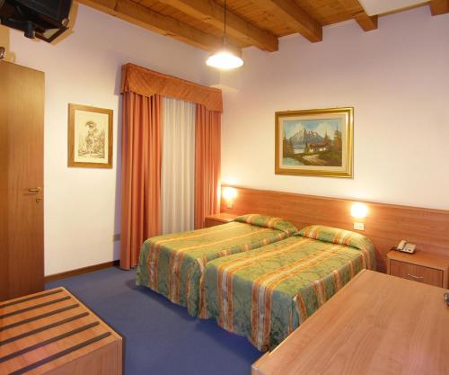 リド・ディ・イエゾロにあるHotel Da Bepiのベッドとテーブルが備わるホテルルームです。