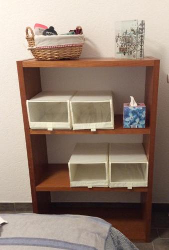 a shelf with three boxes and a basket on it at Le Président 2 in Sierre