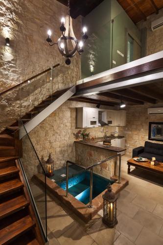 a large living room with a staircase and a kitchen at Oinoessa Traditional Boutique Guest Houses in Lofou