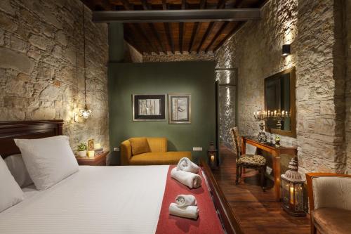 a bedroom with a bed with towels on it at Oinoessa Traditional Boutique Guest Houses in Lofou