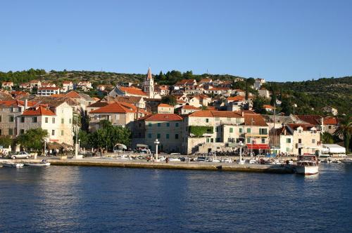 a town on the shore of a body of water at Apartments Neppa in Postira