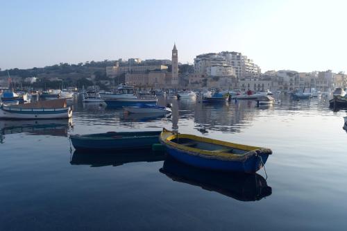 a group of boats sitting in the water at Marsaskala Penthouse Apartment in Marsaskala