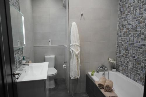 y baño con lavabo, bañera y aseo. en Marsaskala Penthouse Apartment, en Marsaskala