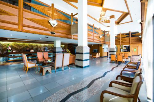 a lobby of a hotel with chairs and a bar at Charoen Hotel in Udon Thani