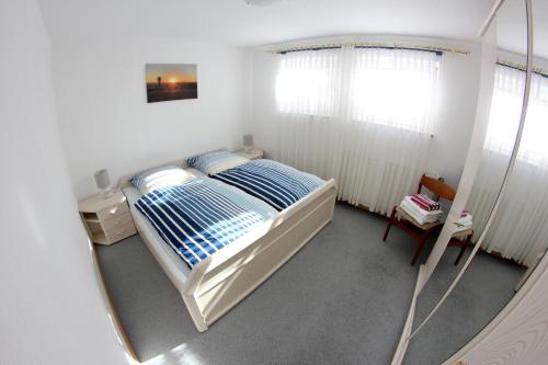Schlafzimmer mit einem Bett und einem Spiegel in der Unterkunft Ruhige und gemütliche Ferienwohnung in Calden in Calden