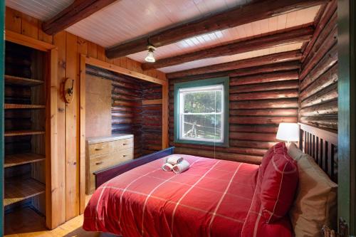 a bedroom with a bed in a log cabin at Les Chalets Sauvignon in Mont-Tremblant