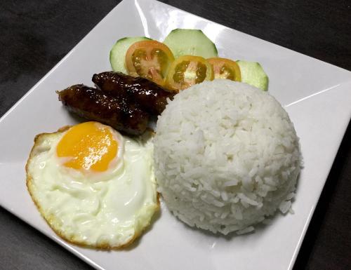 een bord met rijst, vlees en groenten bij LS Garden Villa in Puerto Princesa City