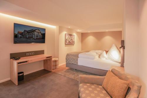 a hotel room with a bed and a couch at Hotel Restaurant Der Engel, Sasbachwalden in Sasbachwalden
