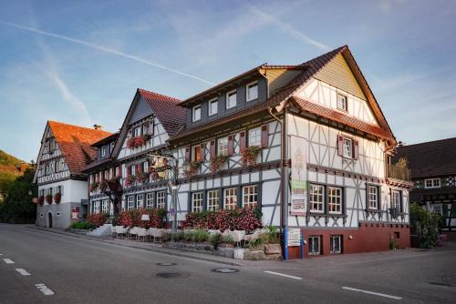 a large white and red building on the side of a street at Hotel Restaurant Der Engel, Sasbachwalden in Sasbachwalden
