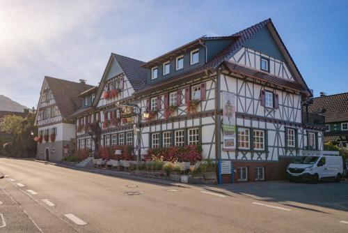 a large white and black building on a street at Hotel Restaurant Der Engel, Sasbachwalden in Sasbachwalden