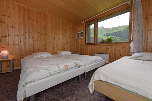 Habitación de madera con 2 camas y ventana en Motel Bivouac de Napoléon en Bourg-Saint-Pierre