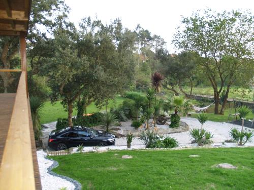 a car parked in a garden with trees and grass at Quintinha do Periqueiro in Castelo do Neiva