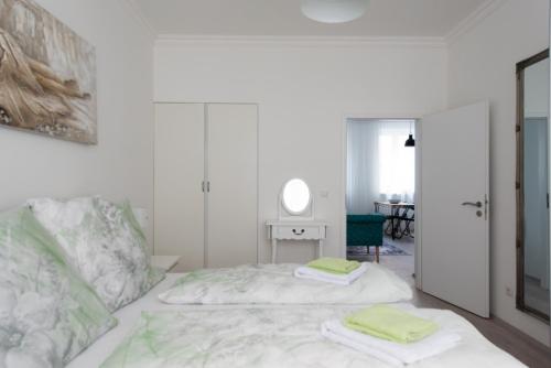 a white bedroom with a bed with two towels on it at Let it be Vienna U1, U2, U4 Karlsplatz Oper in Vienna