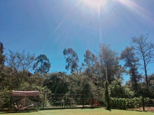 a park with the sun in the sky and trees at Quintinha do Periqueiro in Castelo do Neiva