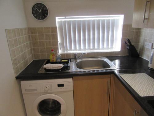a kitchen with a sink and a washing machine at No 6 AT 19 IVANHOE - LARGE 2 BED NEAR SEFTON PARK AND LARK LANE in Liverpool