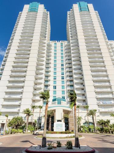 two tall white buildings with palm trees in front at Sapphire in South Padre Island