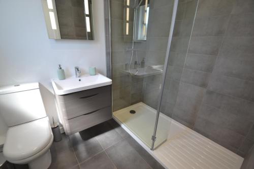 uma casa de banho com um chuveiro, um WC e um lavatório. em Alberts Dairy Cottage em East Cowes