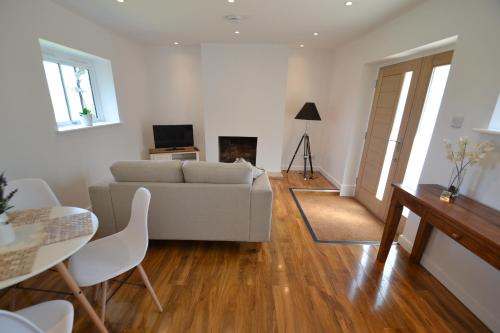a living room with a couch and a table at Alberts Dairy Cottage in East Cowes