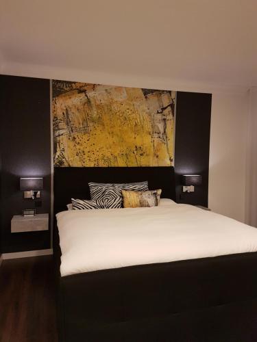 Hohenstadt的住宿－A&M Apartment Ahorn/Hohenstadt，卧室配有一张白色床,墙上挂有绘画作品