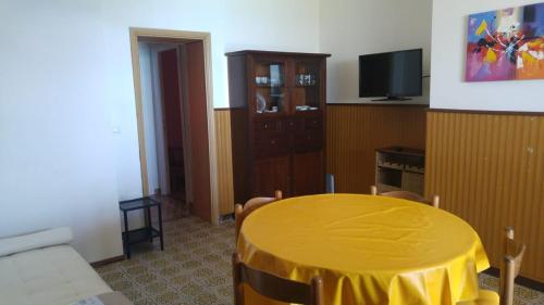 イーゾラ・ロッサにあるFronte Mareのリビングルーム(黄色いテーブル、テレビ付)