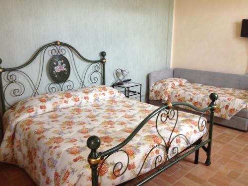 a bedroom with two beds and a couch at il casale san martino in Norcia