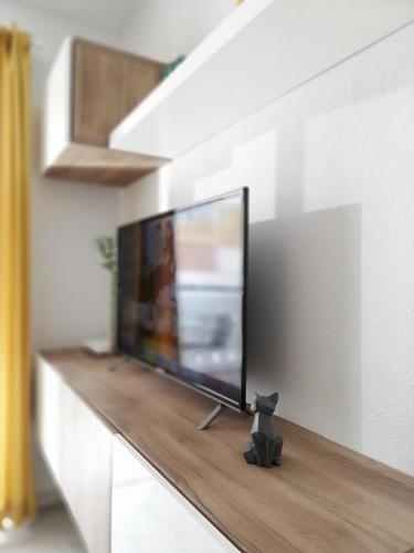 a black cat sitting on a counter in front of a television at Happy Nest in Benalmádena