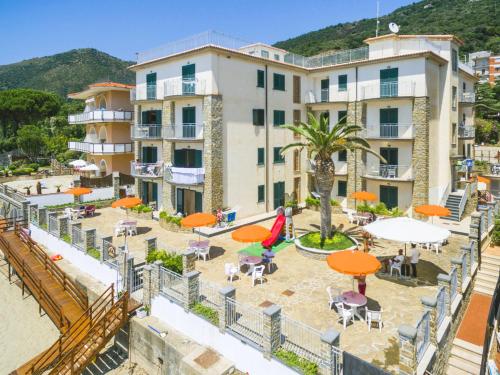 hotel z pomarańczowymi parasolami, stołami i krzesłami w obiekcie Acciaroli Vacanze Residence w mieście Acciaroli