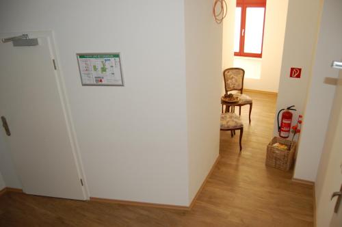 a room with a white wall and a chair and a door at Haus Steuerrad in Stralsund