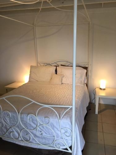 a bedroom with a canopy bed with two lamps at Parkview Brisbane in Brisbane