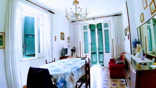 イスキアにあるAppartamento spiaggia 90mtのテーブル付きの部屋、緑のシャッター付きの窓が備わる客室です。