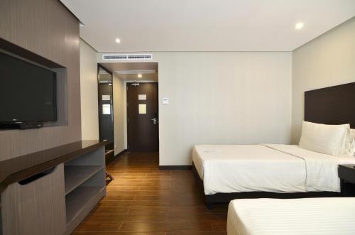 Postel nebo postele na pokoji v ubytování Pearl Garden Hotel