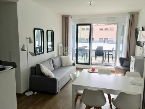 ein Wohnzimmer mit Sofa und Tisch in der Unterkunft Appartement Les terrasses Saint-Malo in Saint-Malo