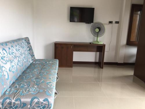 a living room with a couch and a tv at Tara House in Ko Lanta